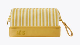 A honey yellow and white striped Béis toiletry bag