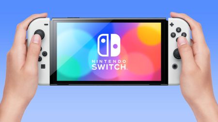 Woman holding white Nintendo Switch OLED console against white background