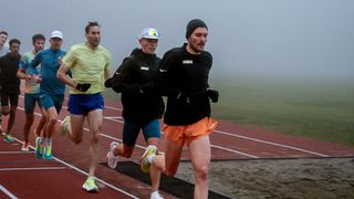 Group of runners training outdoors in misty weather