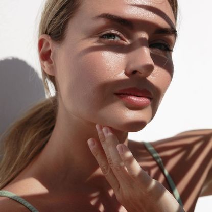 best face tan - a woman basking in the sunshine - getty images 2157576136