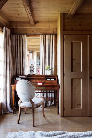 Home office with an antique desk and curtain