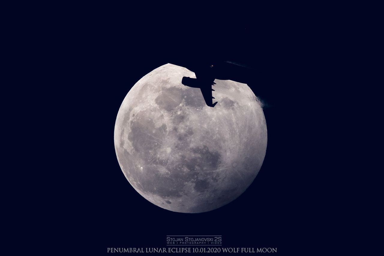 An airplane crosses in front of the Full Wolf Moon during the penumbral lunar eclipse on Jan. 10, 2020, in this photo taken by Stojan Stojanovski near Lake Ohrid in Macedonia.