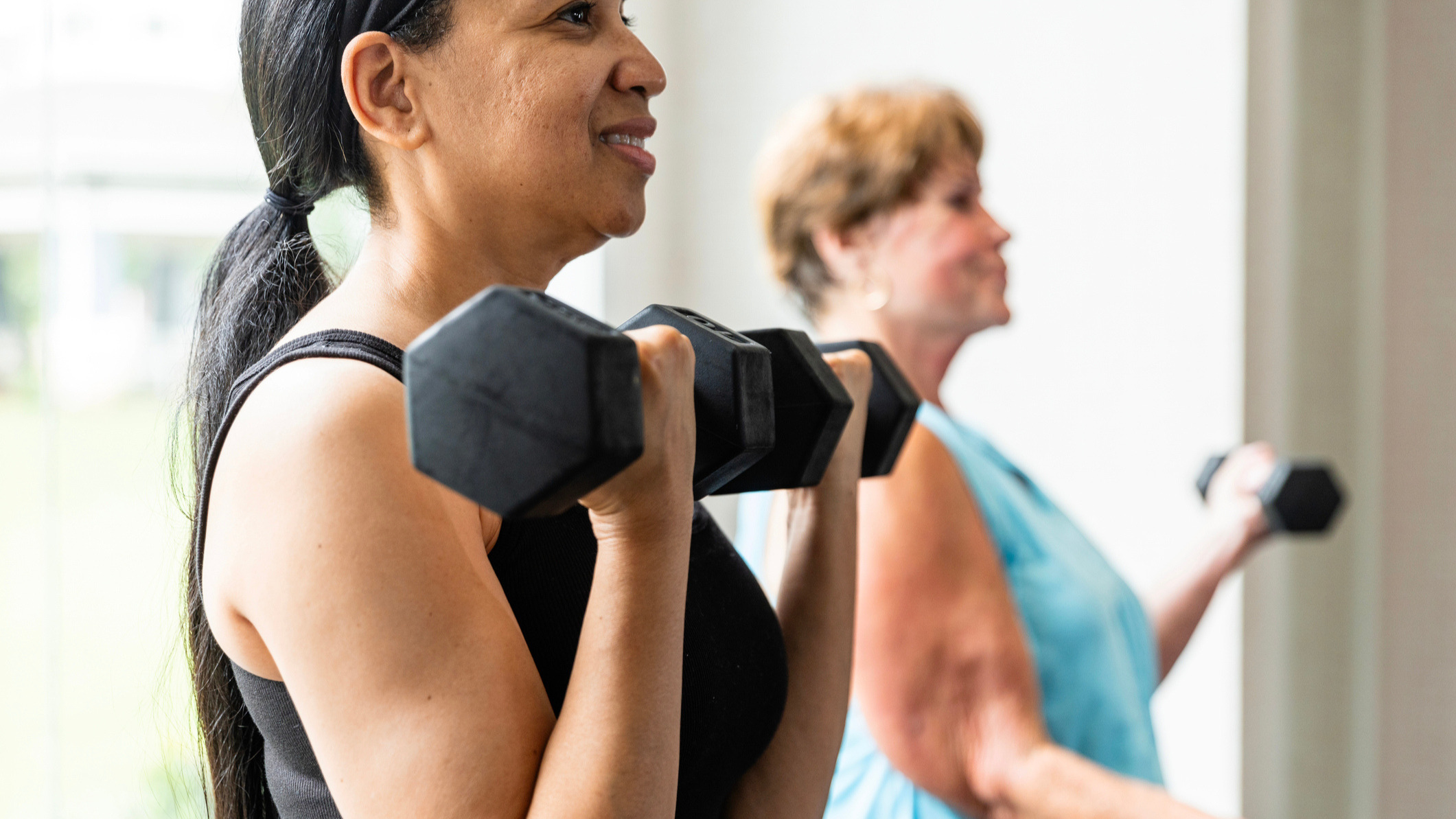 Two women exercising with dumbbells