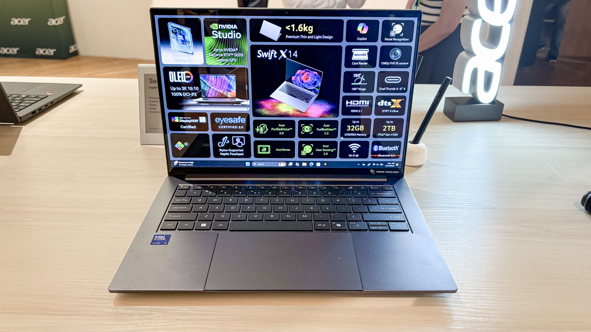 Acer Swift X 14 on table with specs on screen