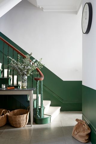 An entryway painted half in a dark green shade