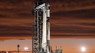 SpaceX&#039;s black and white Polaris Dawn Falcon 9 rocket stands on the launch pad in stunning twilight.