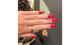 A close-up of Digital Beauty Writer, Sennen Prickett's red almond nails