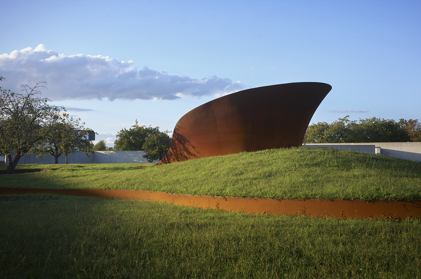 Doshi Retreat at Vitra, a pavilion made of corten steel and minimalist forms seen in the green countryside