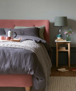 bed by loaf with navy bedding, bedside table and cafetiere on the bed