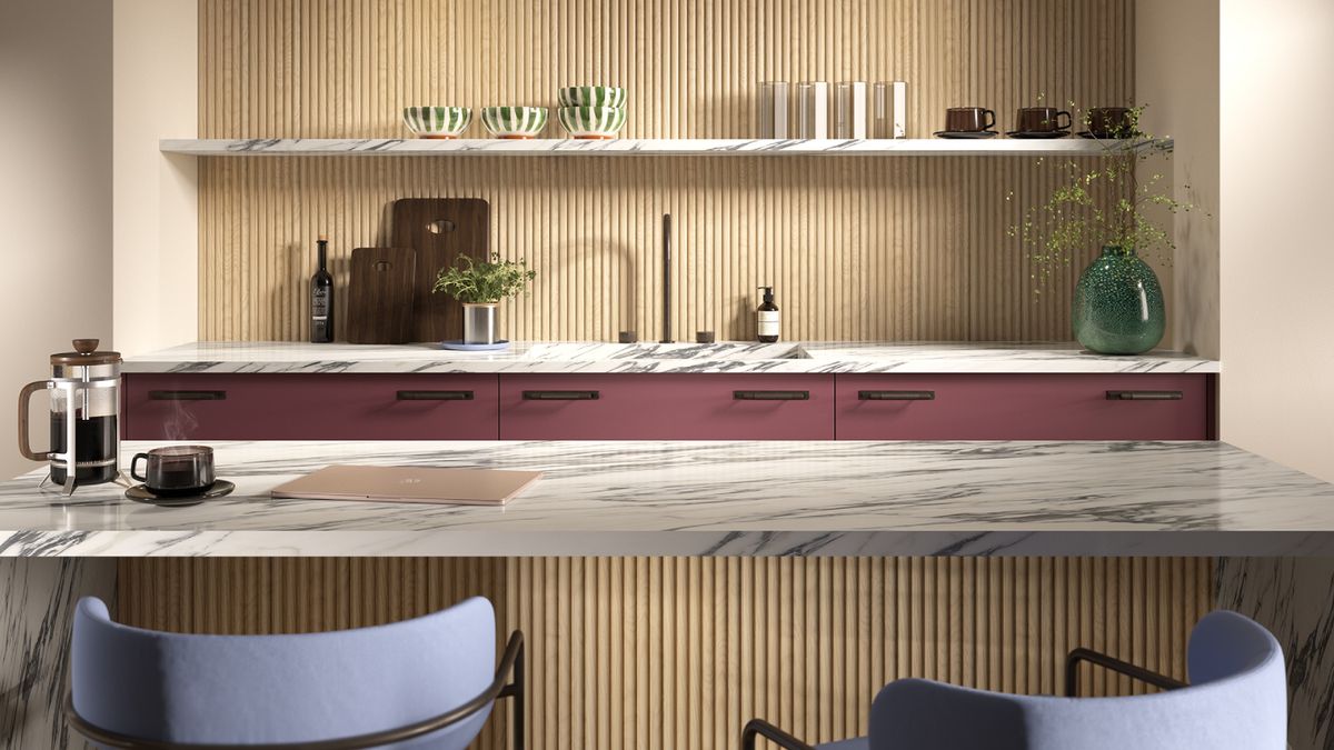 kitchen with light wood reeded wall panelling on back wall, replicated on base of kitchen island with white and grey veined marble top