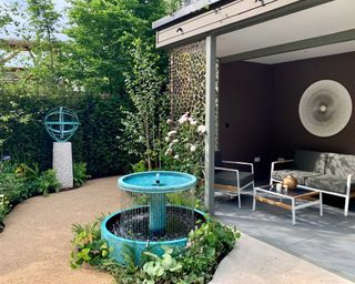 water feature by David Harber in garden with modern pergola