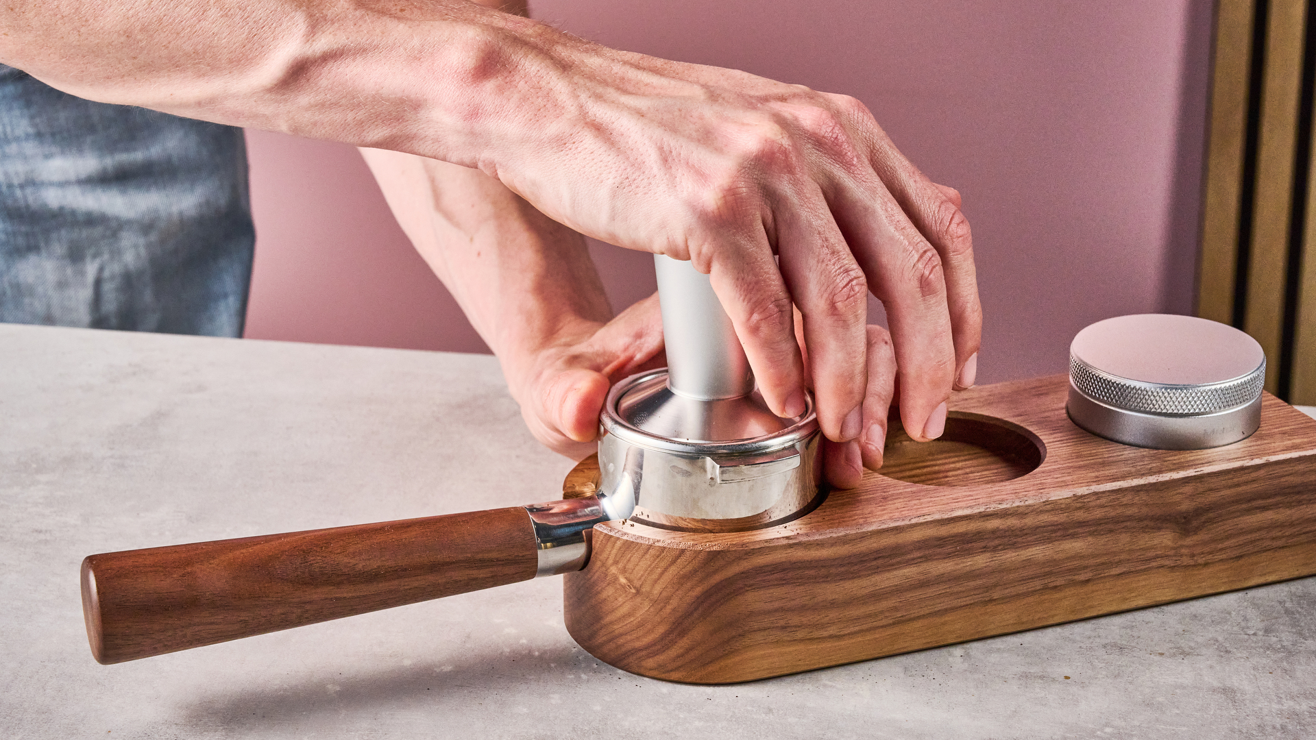 A man tamps the coffee grounds into the Meraki Espresso Machine's portafilter.