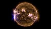 A filtered sun that's yellow and purple. A solar flare is visible to the left.