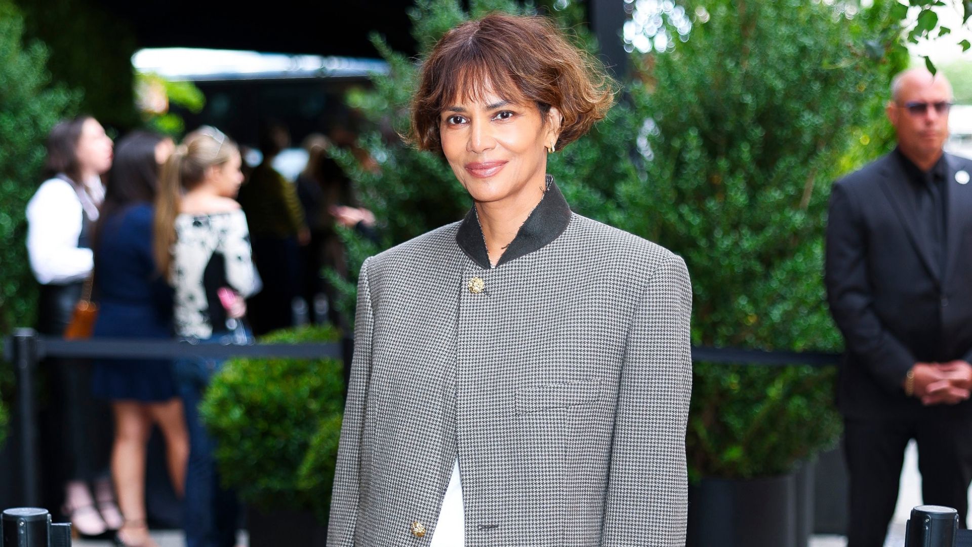 Halle Berry wears low-rise puddle jeans with heels and a single-breasted jacket at a Chanel event in New York.