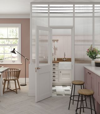 Laundry room separated from main kitchen with ribbed glass doors and windows by Masterclass Kitchens