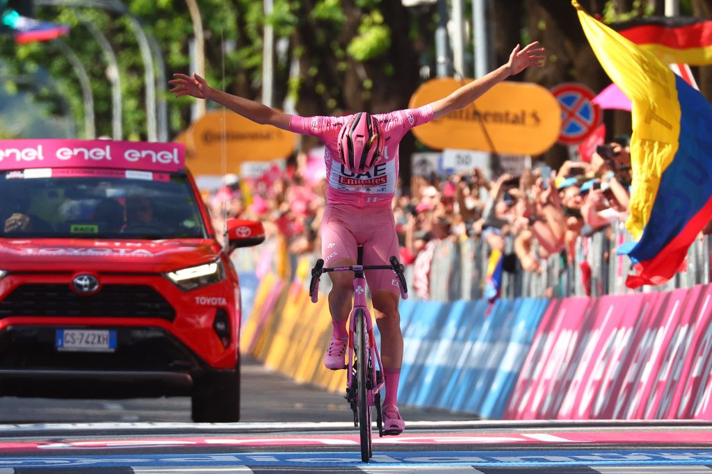 Team UAE's Slovenian rider Tadej Pogacar wearing the overall leader's pink jersey celebrates as he crosses the finish line to win the 20th stage of the 107th Giro d'Italia cycling race, 184km between Alpago and Bassano del Grappa on May 25, 2024. (Photo by Luca Bettini / AFP)