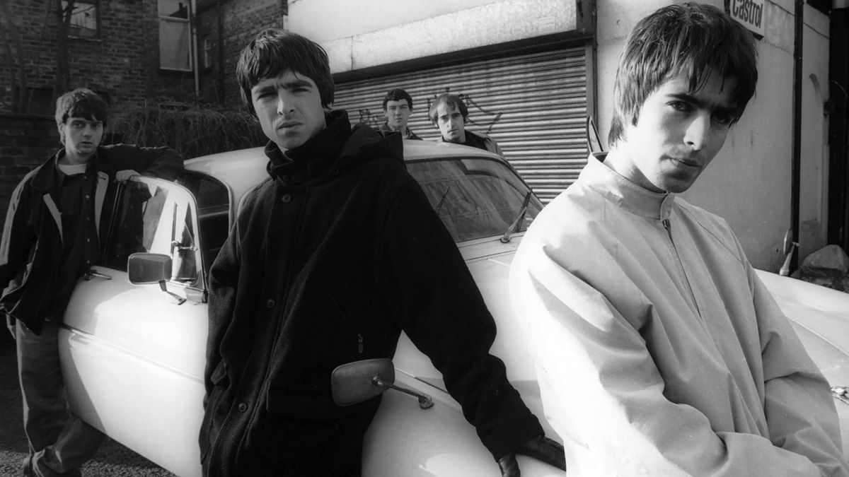 Group portrait of British rock band Oasis leaning against a Jaguar XJ6 car in Withington, Manchester, United Kingdom, 30th November 1993. L-R Paul McGuigan, Noel Gallagher, Tony McCarroll, Liam Gallagher, Paul Arthurs (aka Bonehead)