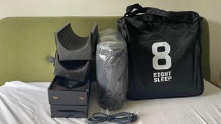 Eight Sleep Pod 3 on a bed, unboxed