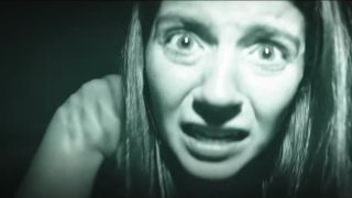 Emily Bader looks into the camera frightened in Paranormal Activity: Next of Kin.