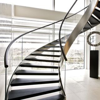 curved staircase with glass window