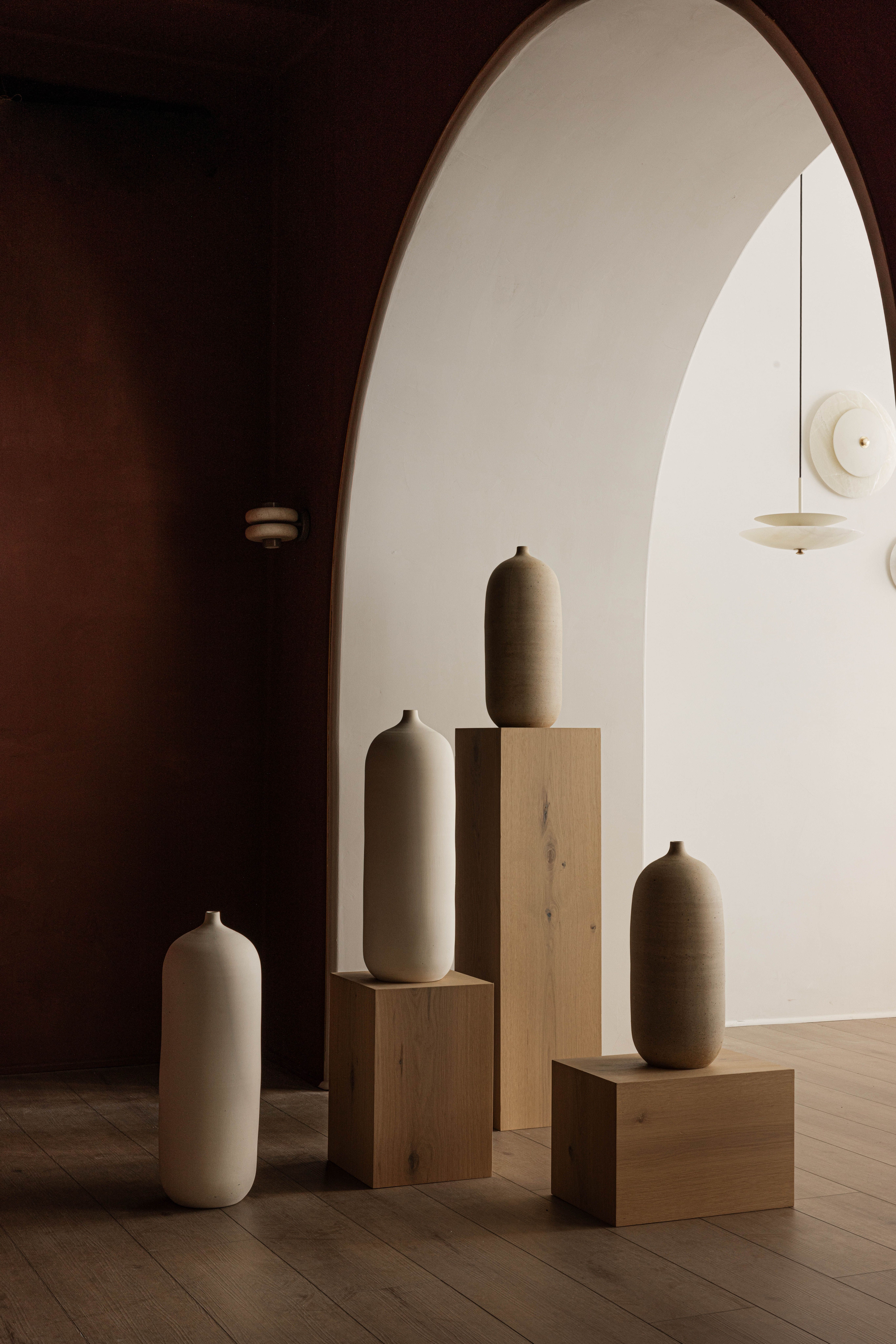 An archway above tall ceramic vessels.
