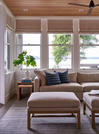 Coastal style sunroom with wood clad ceiling, fan and neutral sofa