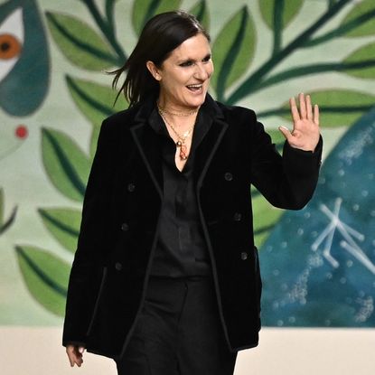 Maria Grazia Chiuri waves to the audience after she steps down from Dior