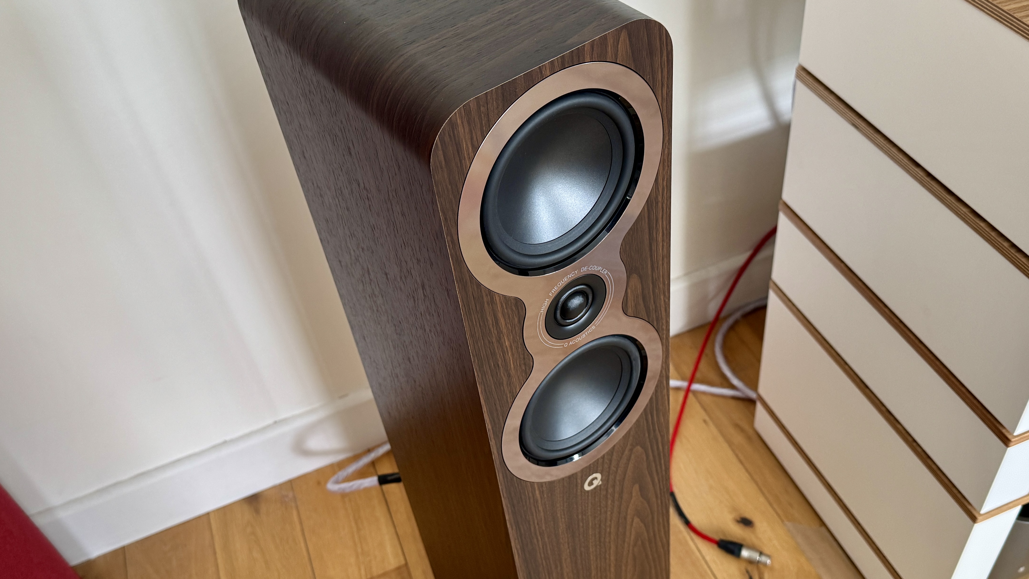 Q Acoustics 3040c speakers in a white listening room, with a hi-fi stack and turntable between them