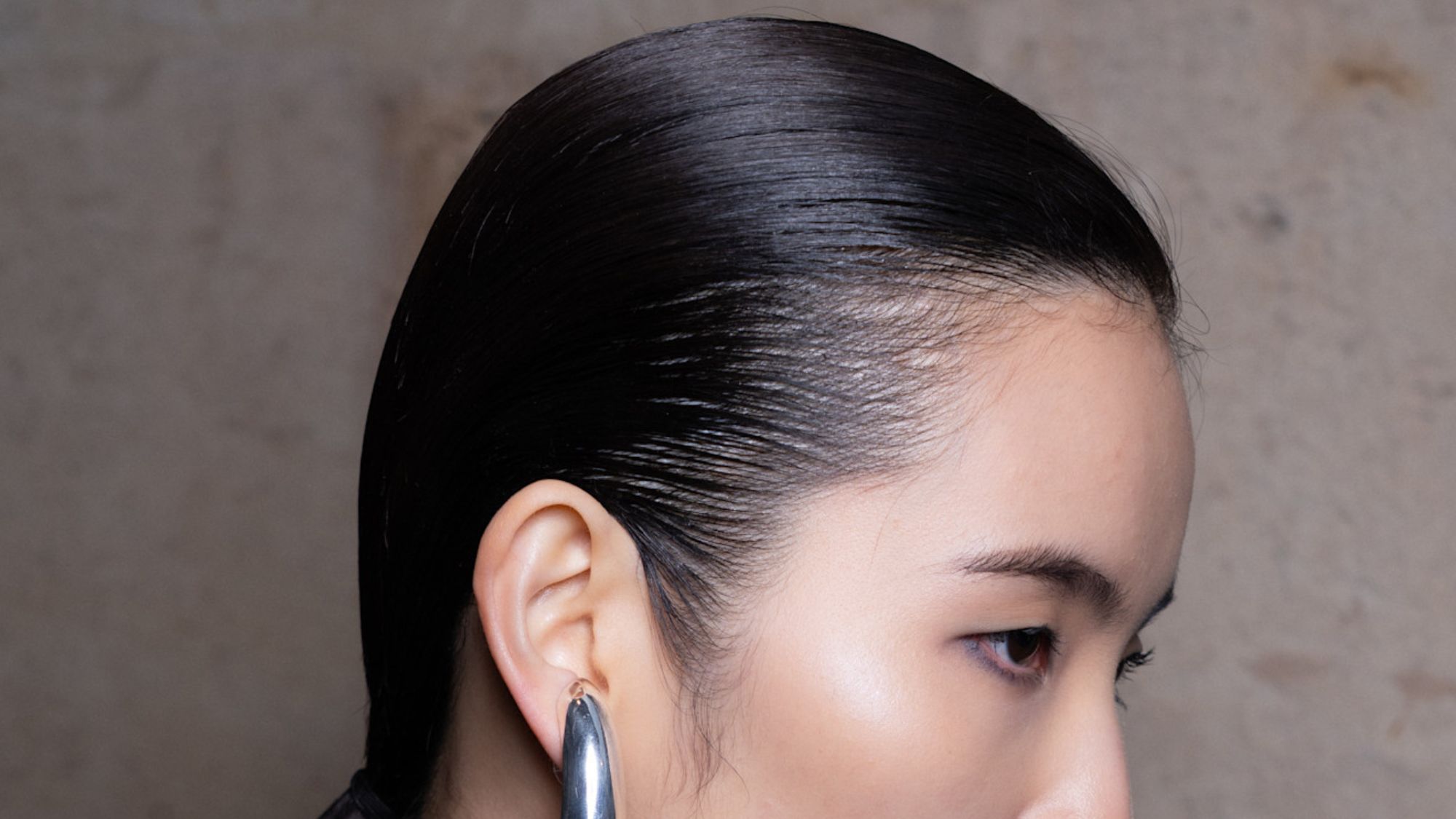 model looking to the slide with slicked hair