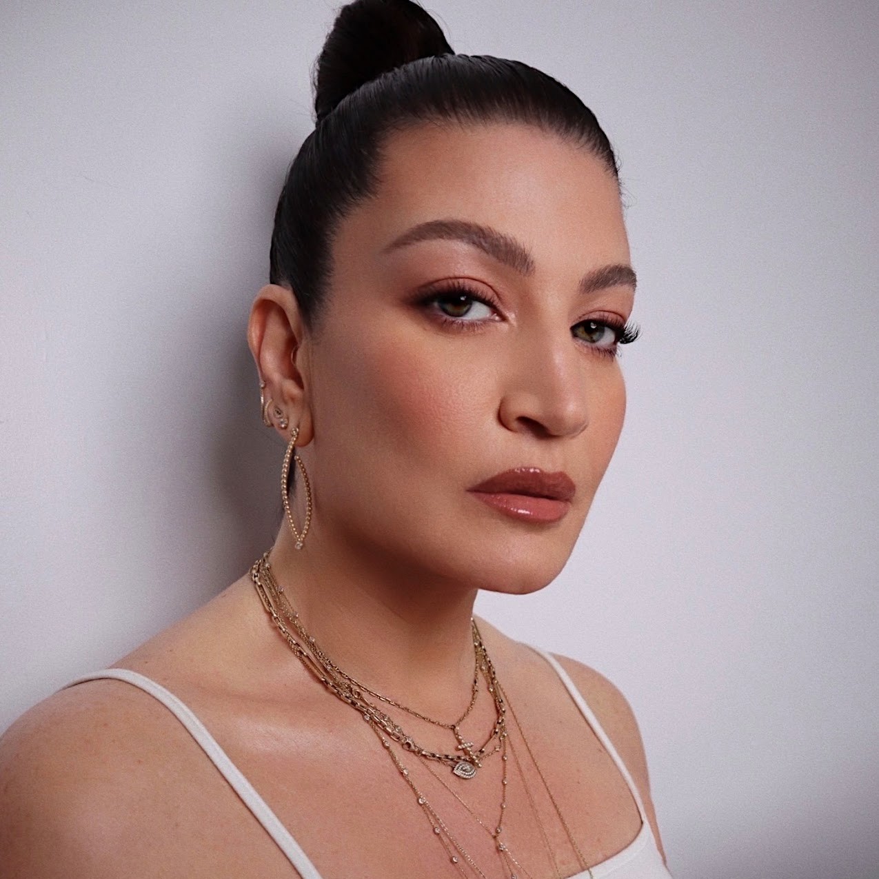 A woman with a slicked-back bun, Danielle Priano, poses for a headshot.