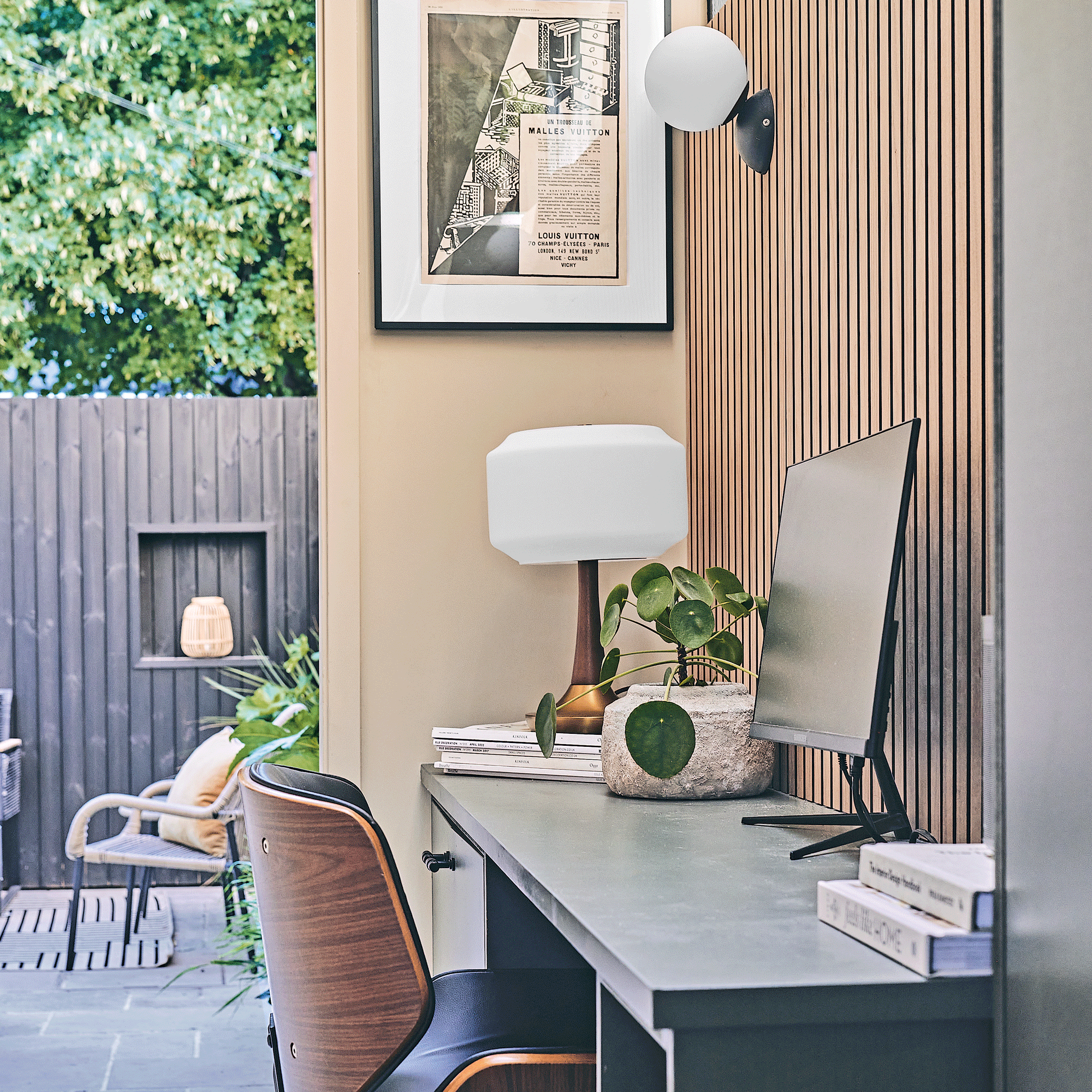 a small home office space with vertical wall panelling leading out into a small patio area
