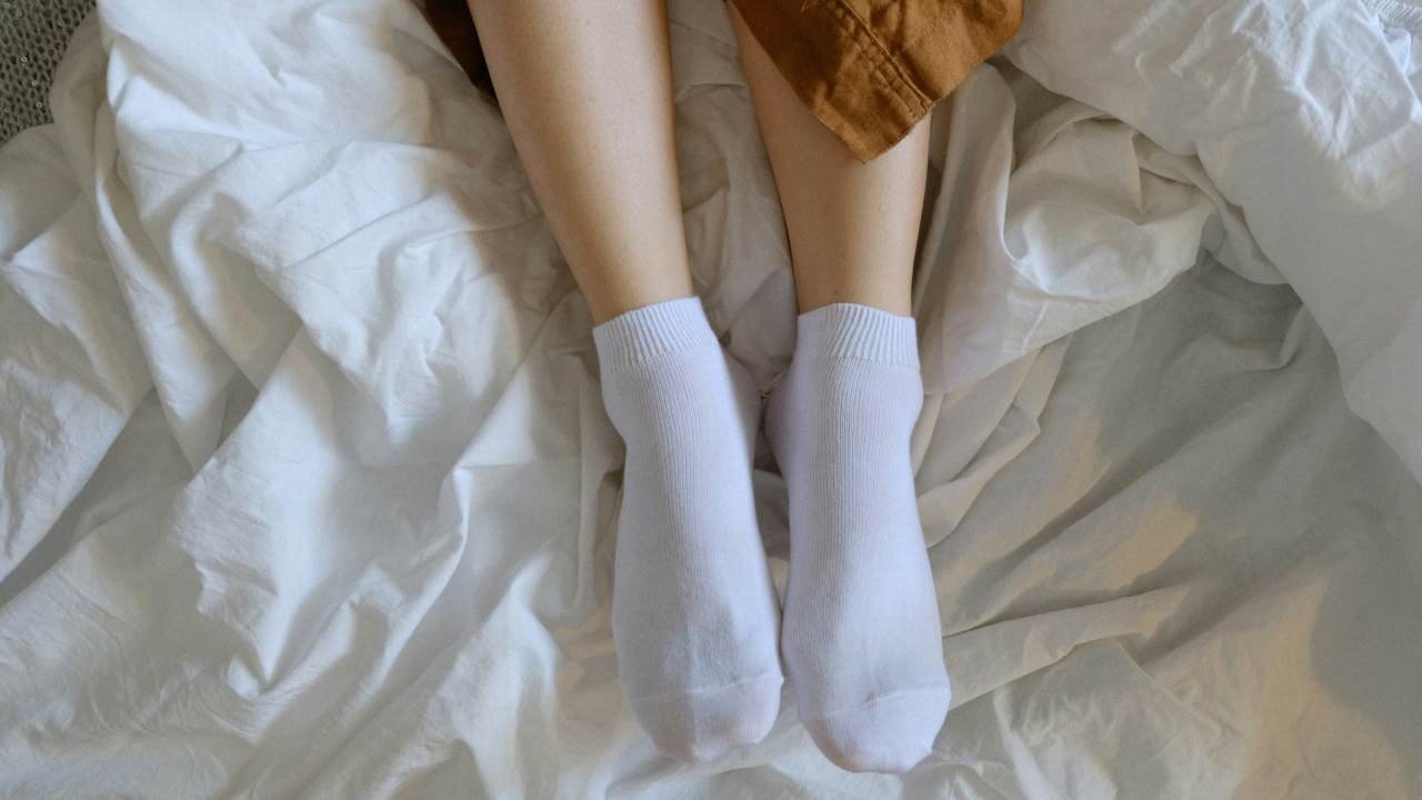 A person wearing socks in bed