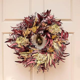 A red and yellow fall-themed wreath from Anthropologie