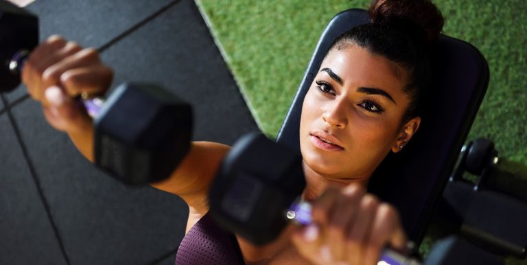 Woman training with dumbbells in a gym