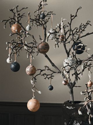 Marbled baubles in earthy tones suspended off branches in a vase