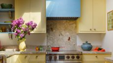 A kitchen painted yellow with pops of color via the accessories 