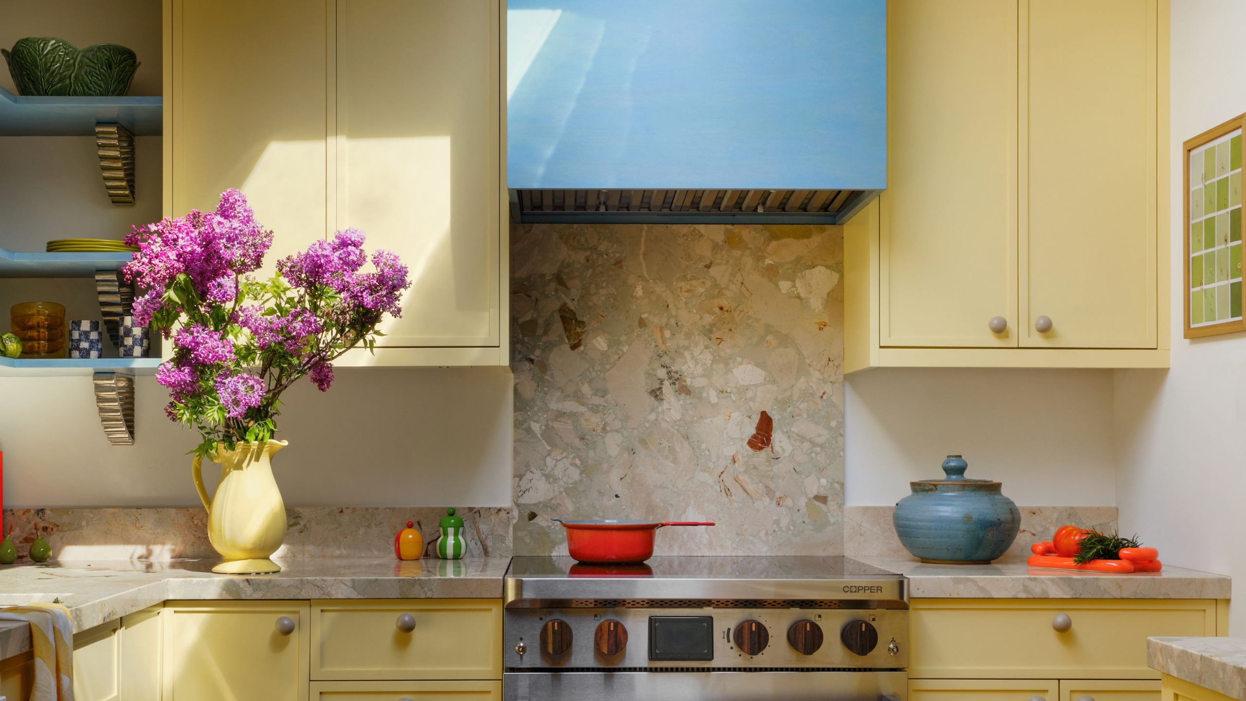 A kitchen painted yellow with pops of color via the accessories 