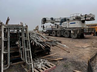 A crane and pipes on land.