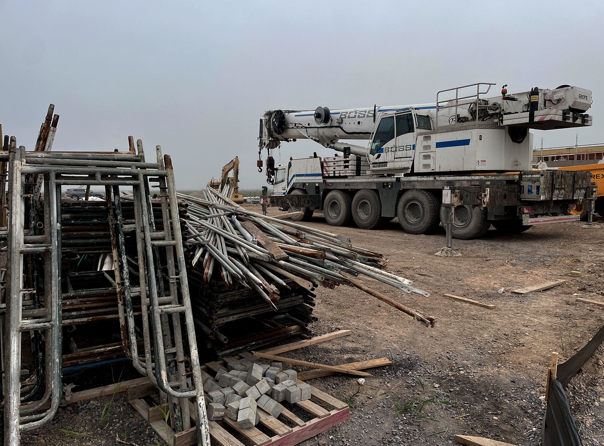 A crane and pipes on land.