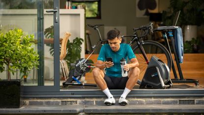 Sam looking at his phone after completing an indoor cycling workout