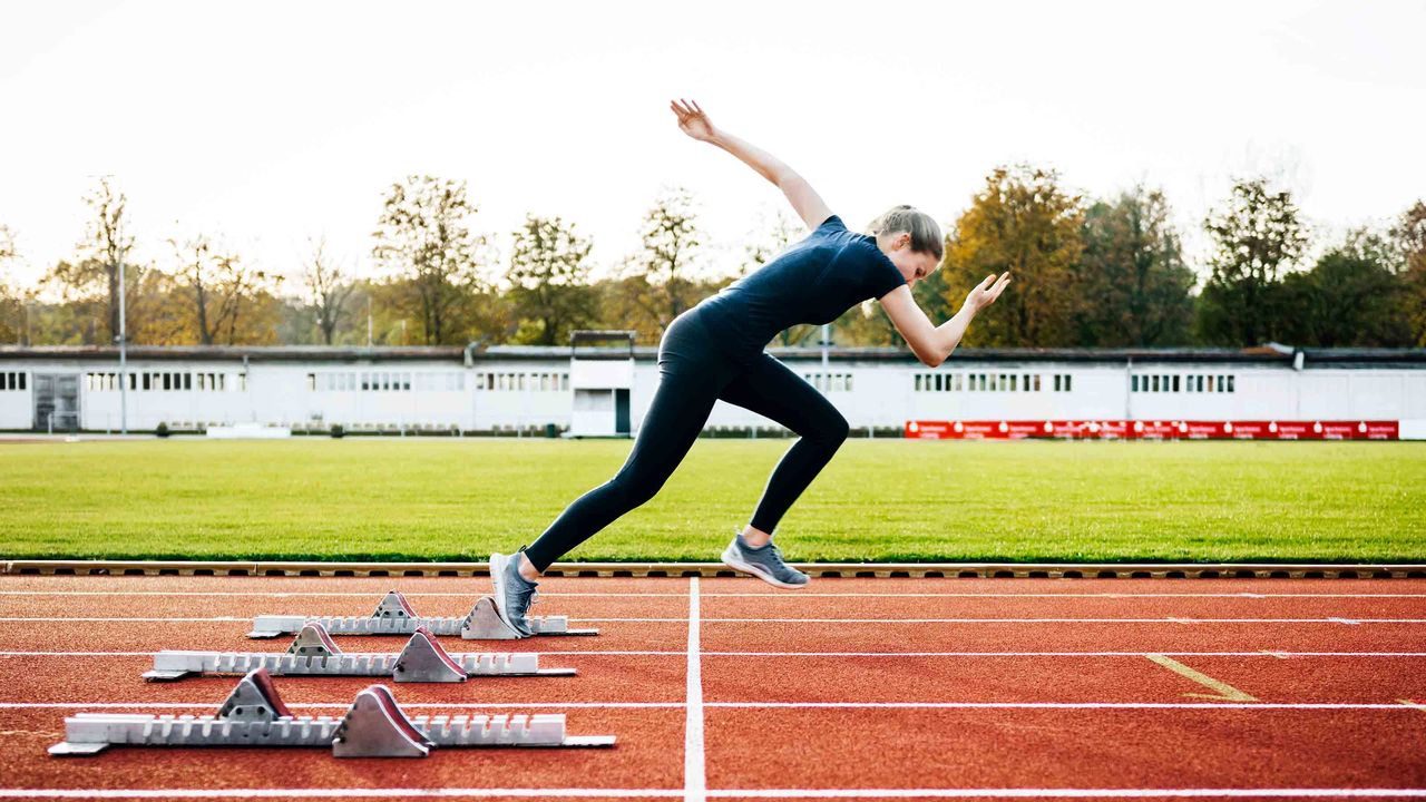 A woman sprints out of the starting blocks