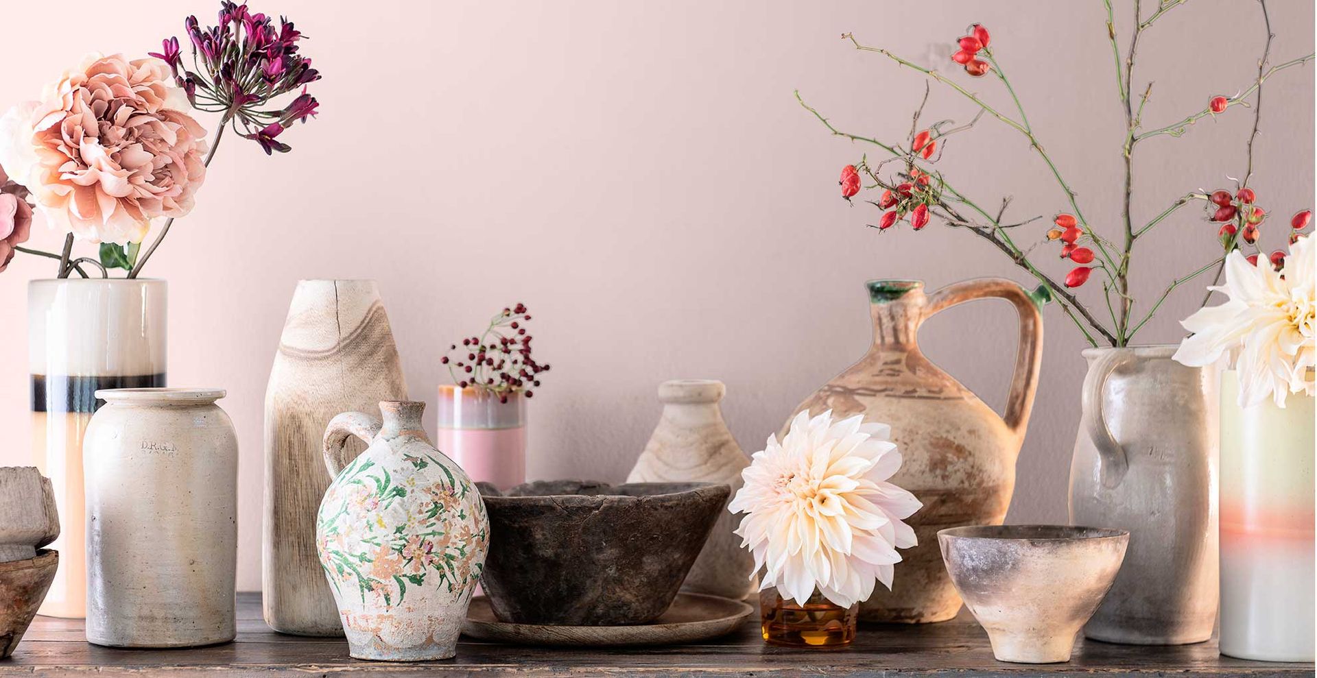 Dulux Colour of the year of the year 2024 Sweet Embrace painted on a wall behind a sideboard with flowers and vases