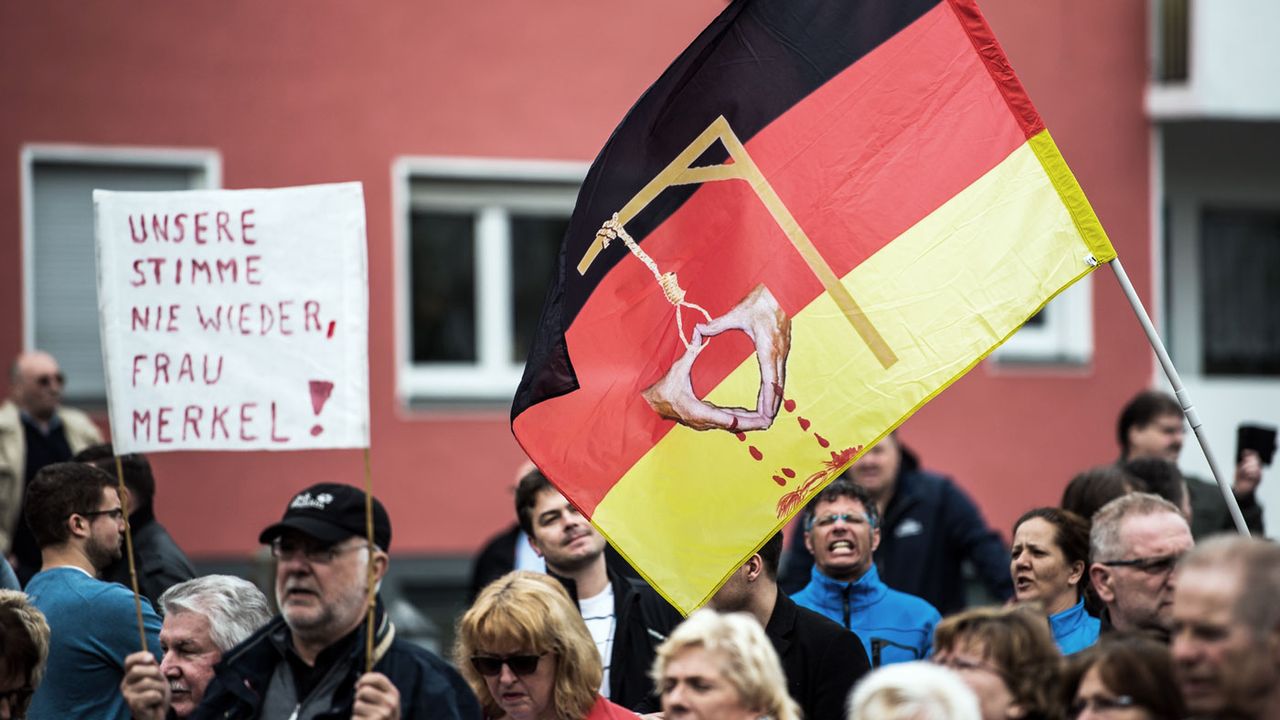 AfD supporters in Essen carry a sign saying, &amp;#039;Never our voice again, Mrs Merkel&amp;#039;