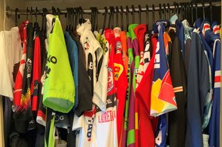 A row of cycling jerseys in a wardrobe