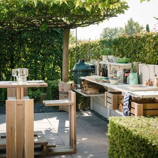 garden kitchen with white counter and wooden dinning table with chair