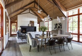 living room dining room combo in a barn-style conversion with modern chairs and pendant lights