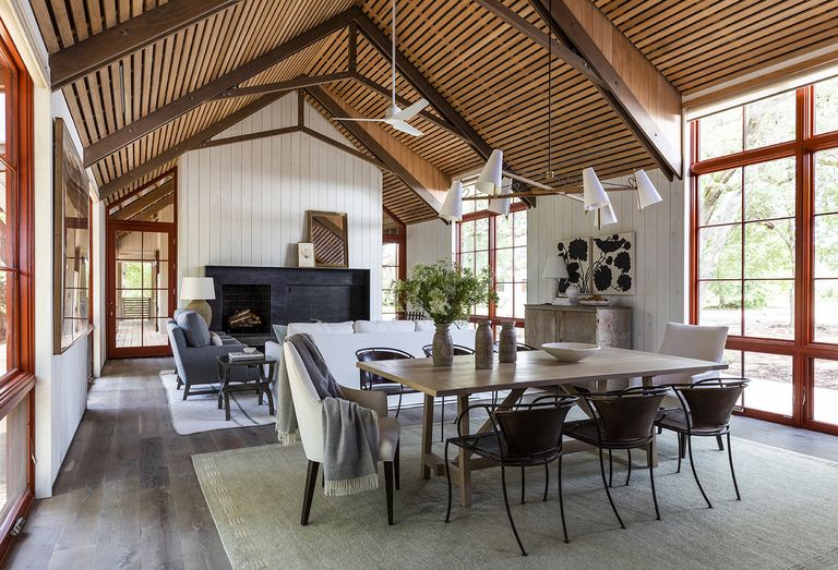 living room dining room combo in a barn-style conversion with modern chairs and pendant lights
