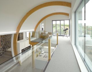 Landing area with clear baluster, floor to ceiling glazing and curved beamed ceiling