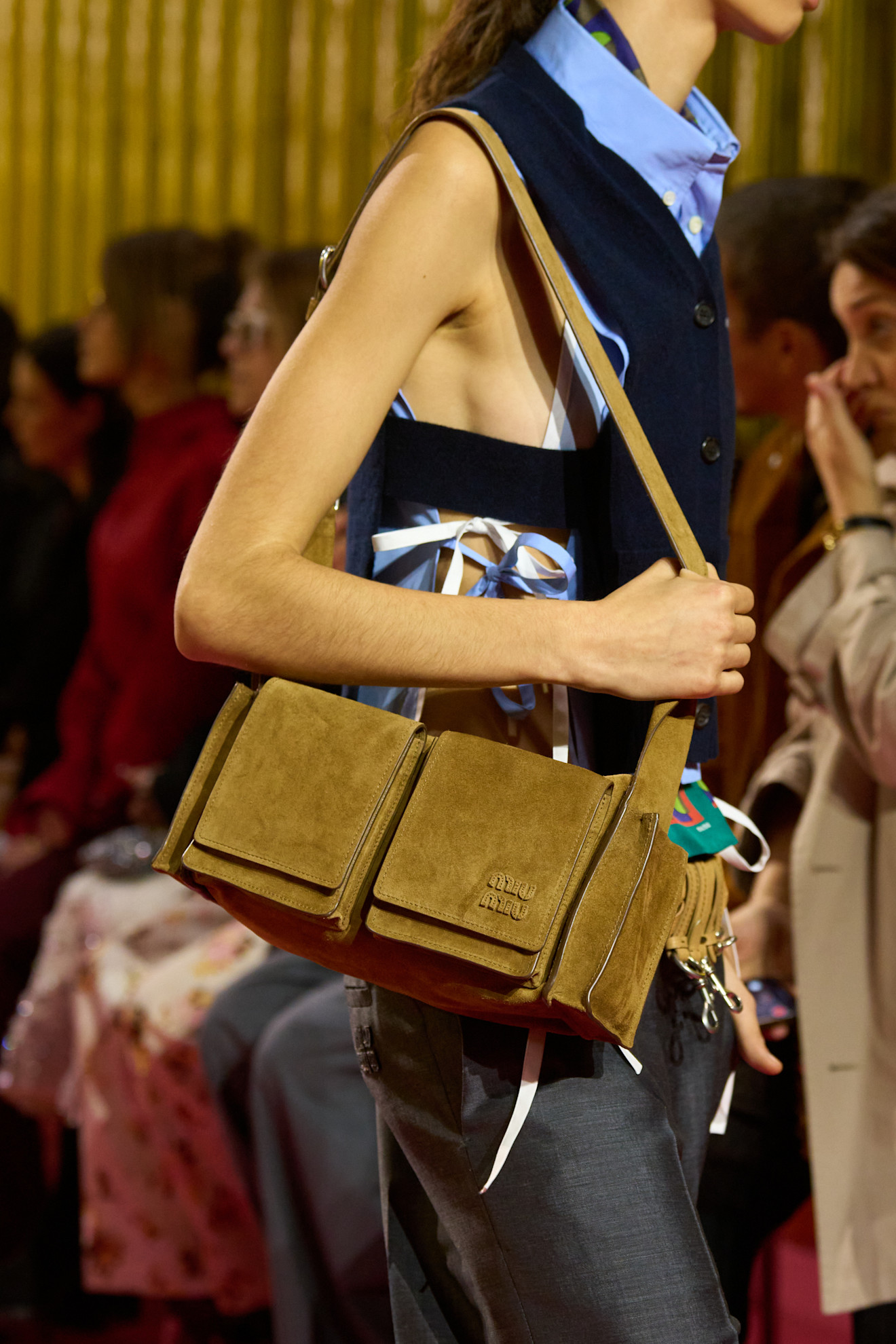 A model carrying a Miu Miu handbag on the runway.