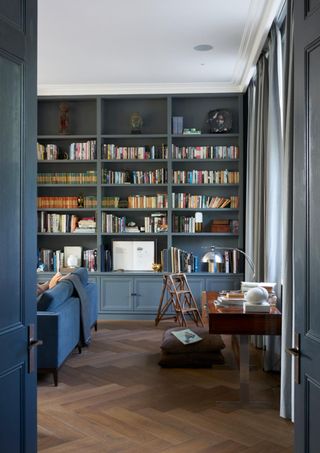 Entrance view of a blue living room and bookshelf wall